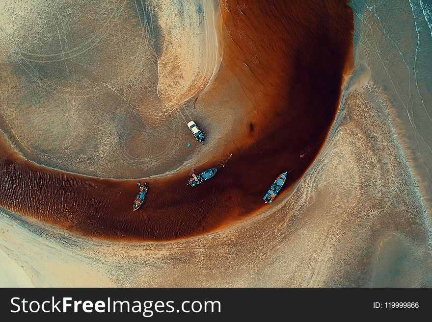 Aerial Photography of Four Blue Boats on Body of Water