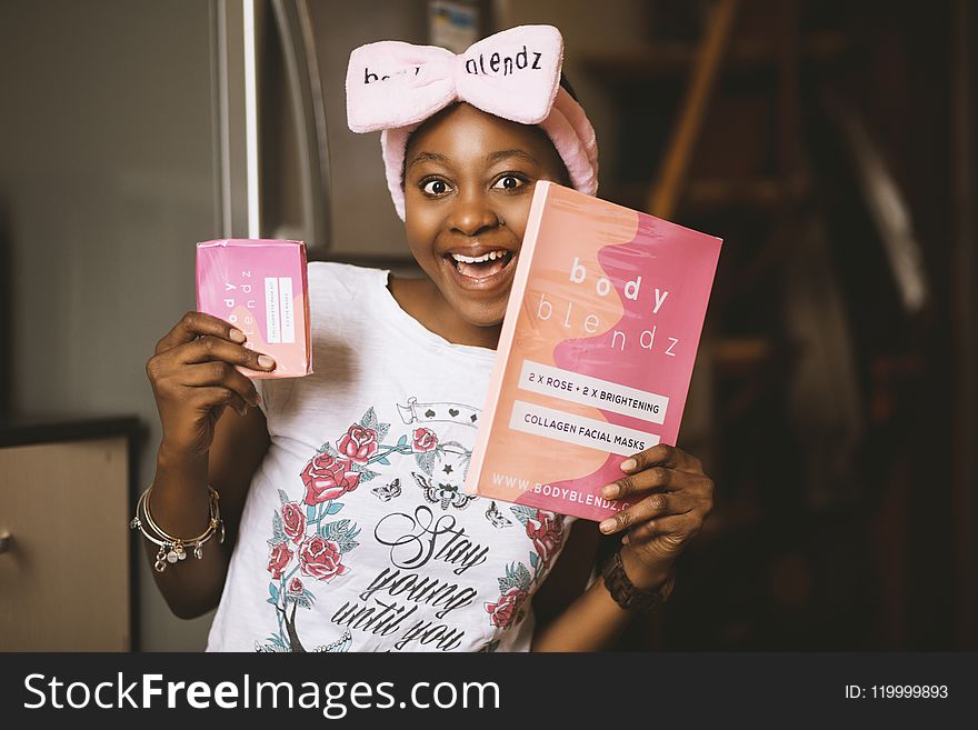 Woman Holding Book and Pink Box