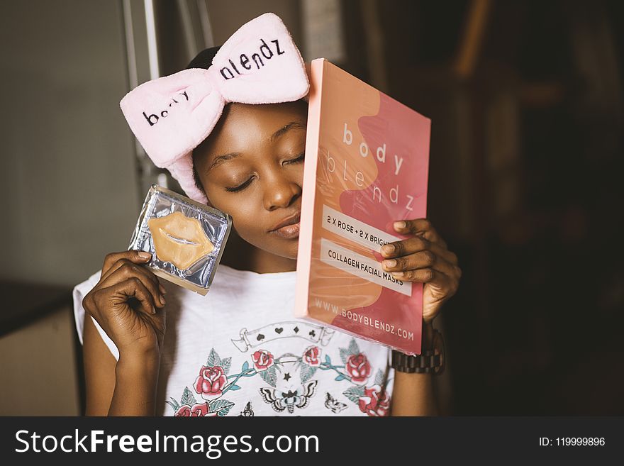 Girl Wearing White and Red Floral Shirt With Bow Headband Closing Her Eyes While Holding Body Blendz Book