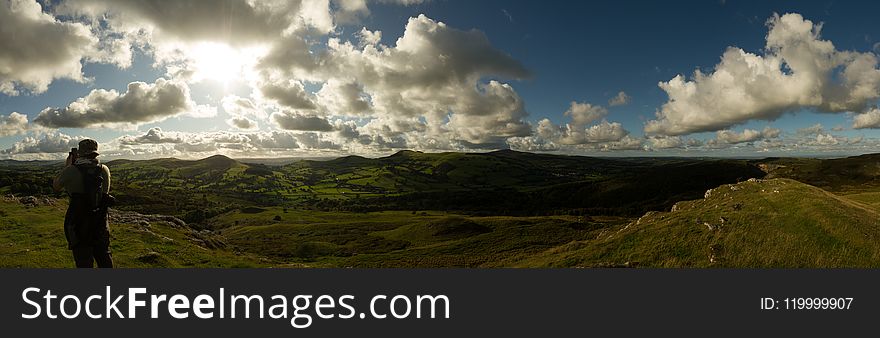 Person Standing On Green Grass Under Blue Sky Photography