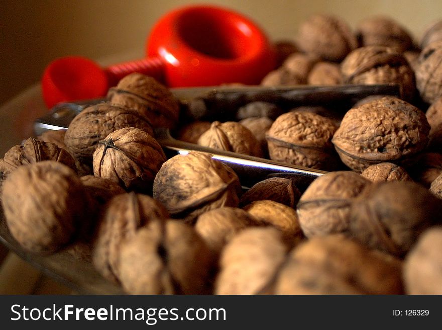 A bowl with walnuts and a nutcracker in the background