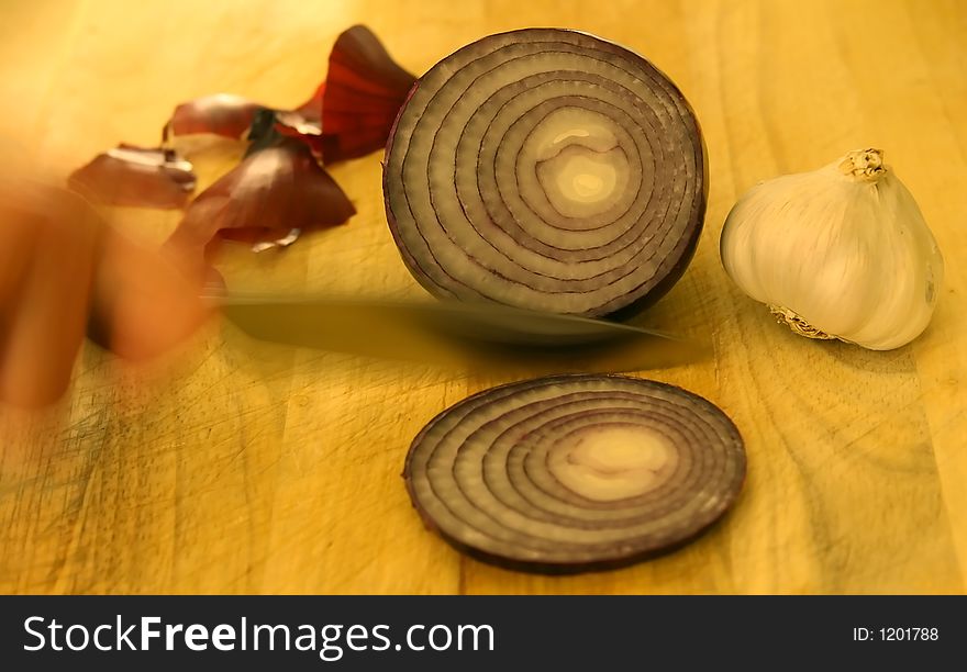 Onions and garlic on chopping board with knife, macro close up with copy-space, copy space. Onions and garlic on chopping board with knife, macro close up with copy-space, copy space.