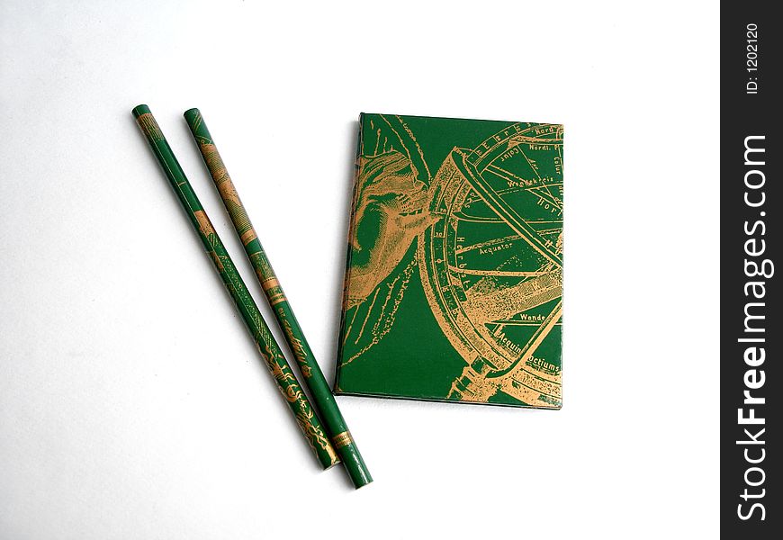 Green Notebook With Two Green Pencils On A White Background