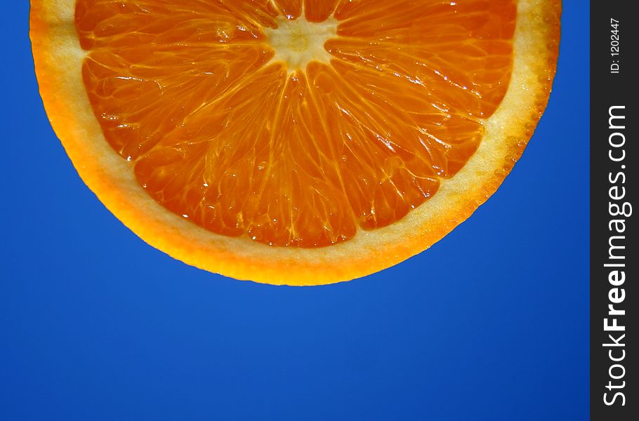 Macro shot of an orange slice with a sky background
