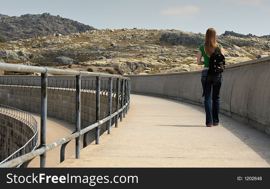 Woman walking on the side of the dam