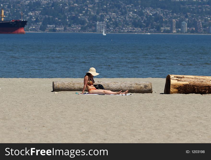 Pretty woman sunbathing at the beach while on vacation