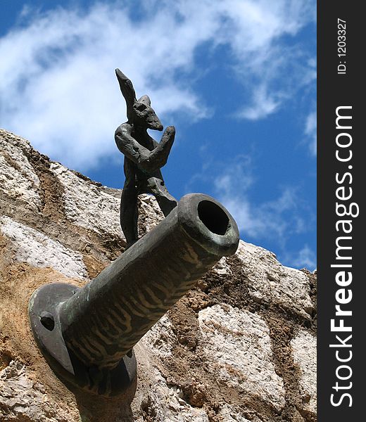 Cannon figure in a harbour wall in Spain.