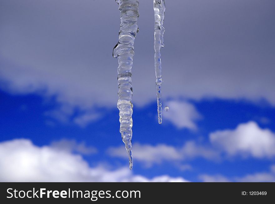 Icicles hanging with blue sky and clouds in the background. Icicles hanging with blue sky and clouds in the background