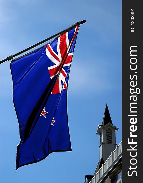 Vertical photo of foreign flag and church steeple with blue sky. Vertical photo of foreign flag and church steeple with blue sky