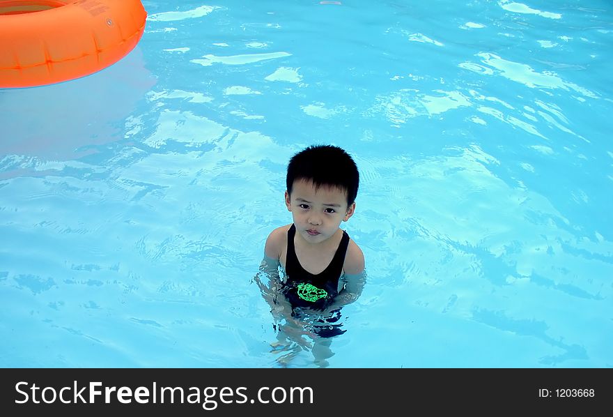 A boy is standing in a pool