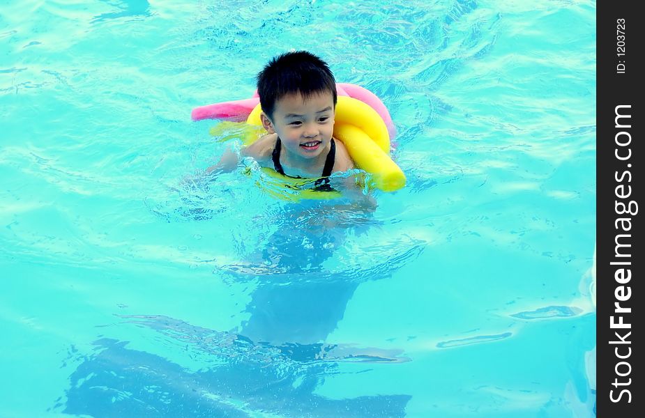 A boy is swimming in a pool