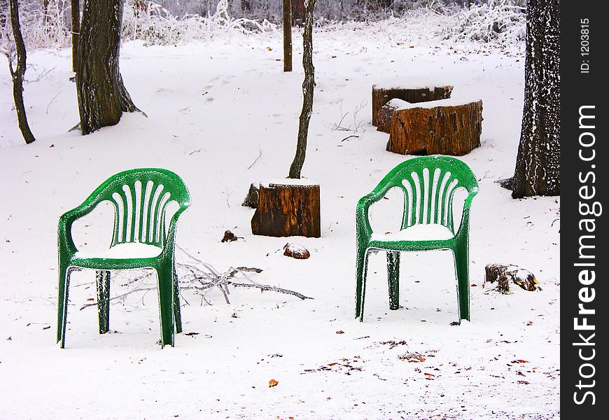 Two forgotten chairs snowed up in the woods. Two forgotten chairs snowed up in the woods
