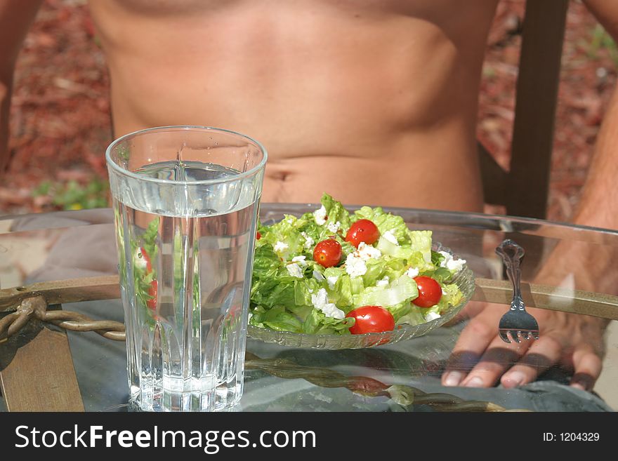 Toned male enjoying a salad. Toned male enjoying a salad