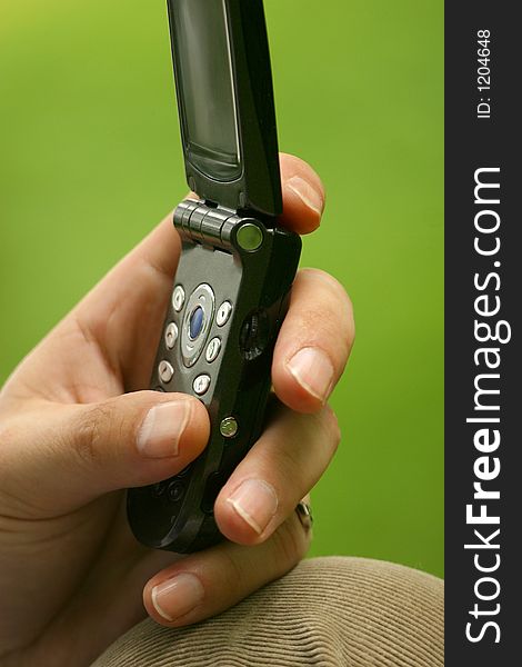 The image of the man's hand pressing on the buttons of the mobile phone. The image of the man's hand pressing on the buttons of the mobile phone