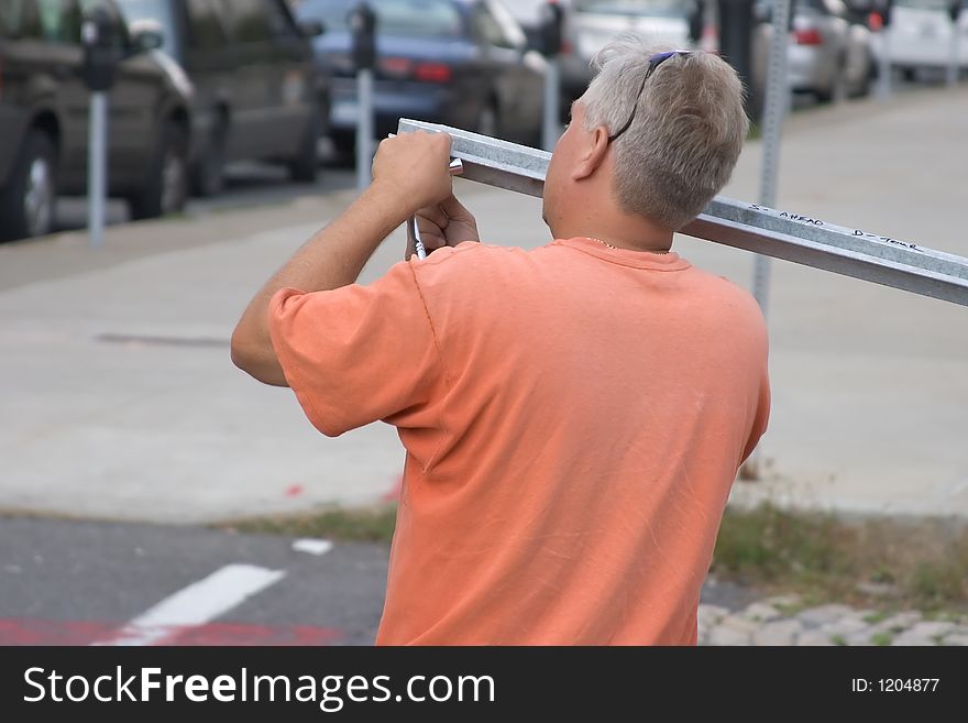 Workman Using Tools to Repair a Metal Post. Workman Using Tools to Repair a Metal Post