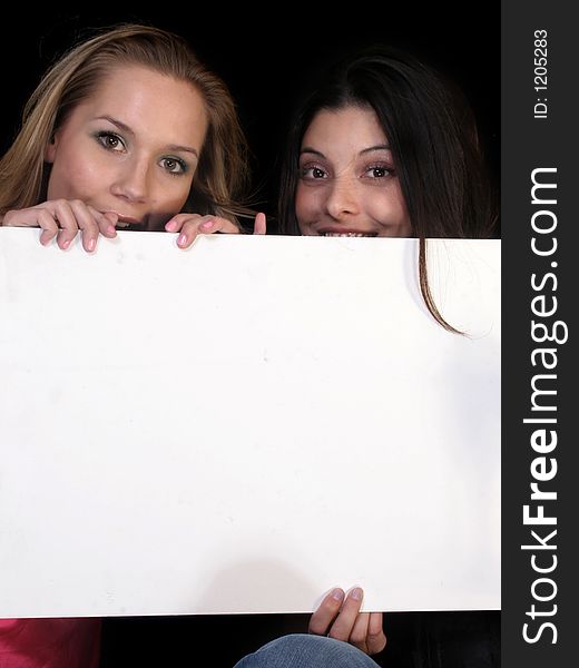 Two women holding a sign with space for your advertisement. Two women holding a sign with space for your advertisement