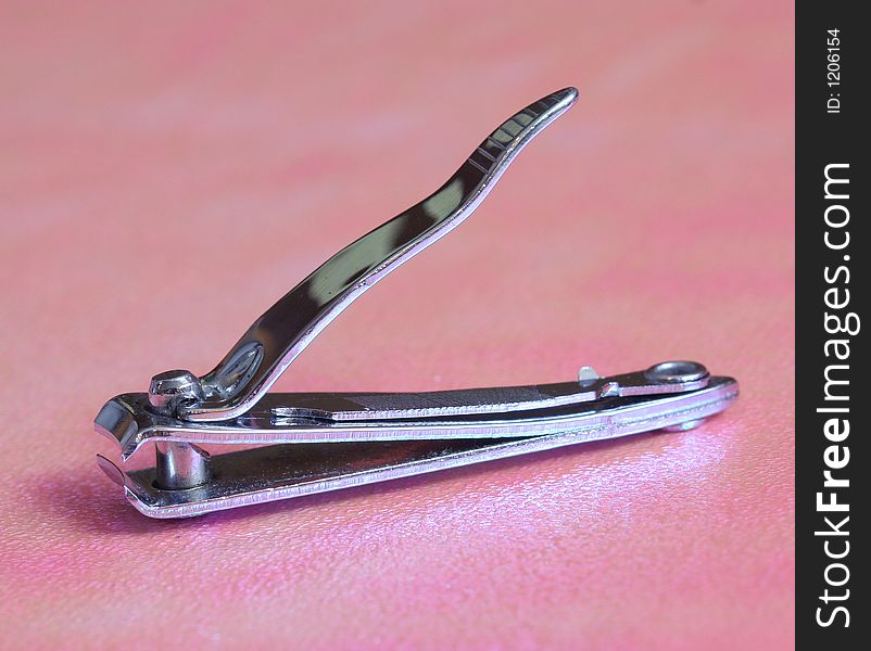 Metal nail cutter in a pink background