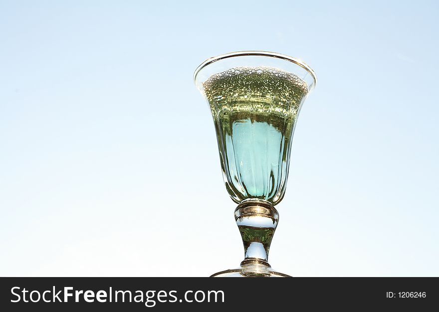 Blue coktail glass with sky in backround