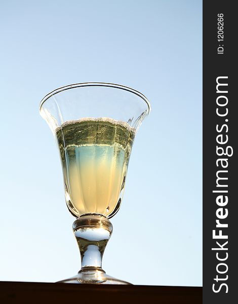 Blue coktail glass with sky in backround