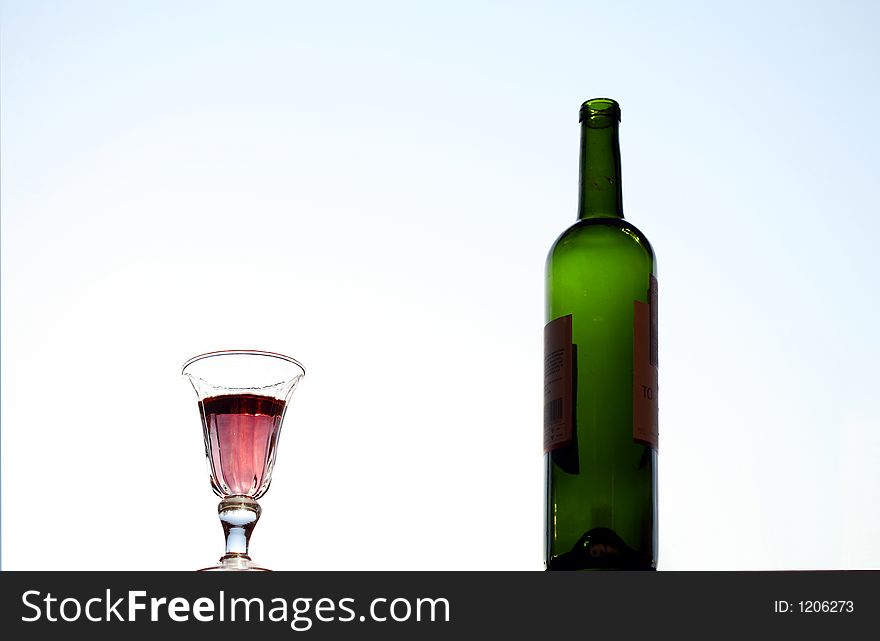 Wine glass and  bottle with light blue background