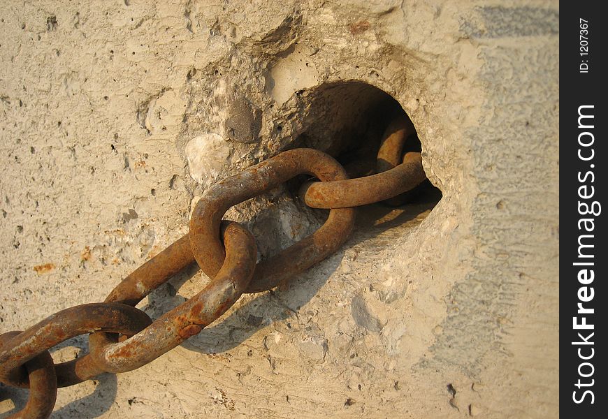 Rusty chain in front of a wall