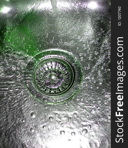 Flowing green water in sink