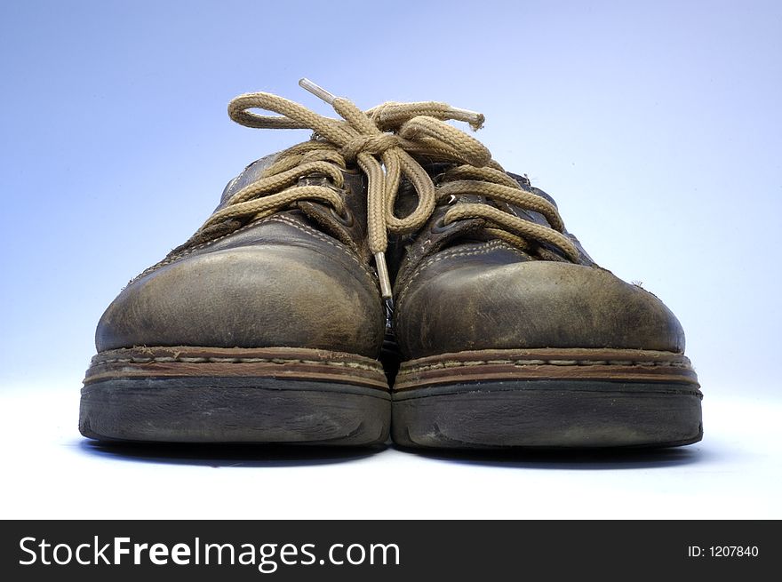 Two children's old shoes with shoelaces.