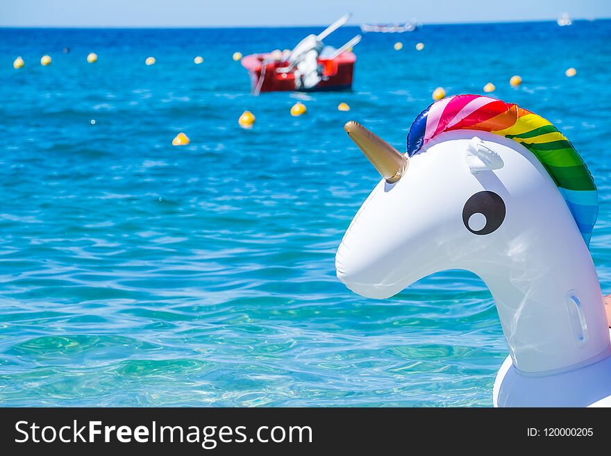 Unicorn swim tube on the beach on sea background. Inflatable rubber unicorn.Fantasy Swim Ring for Summer Pool Trip or
