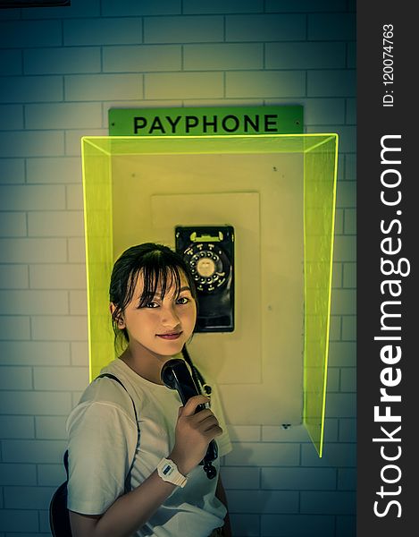 Photo of Woman Standing Beside Payphone.