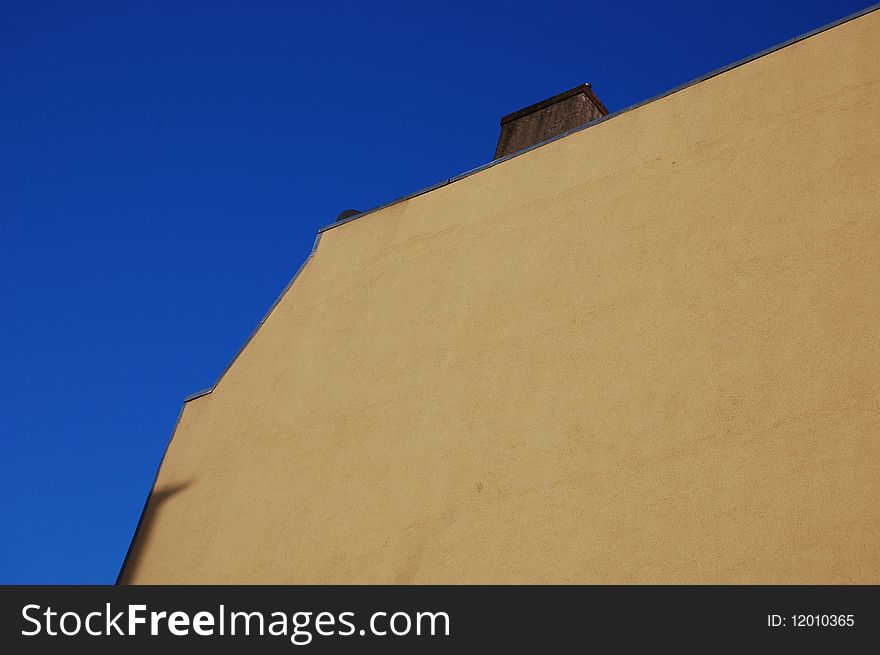 A yellow wall with a blue sky in Amsterdam