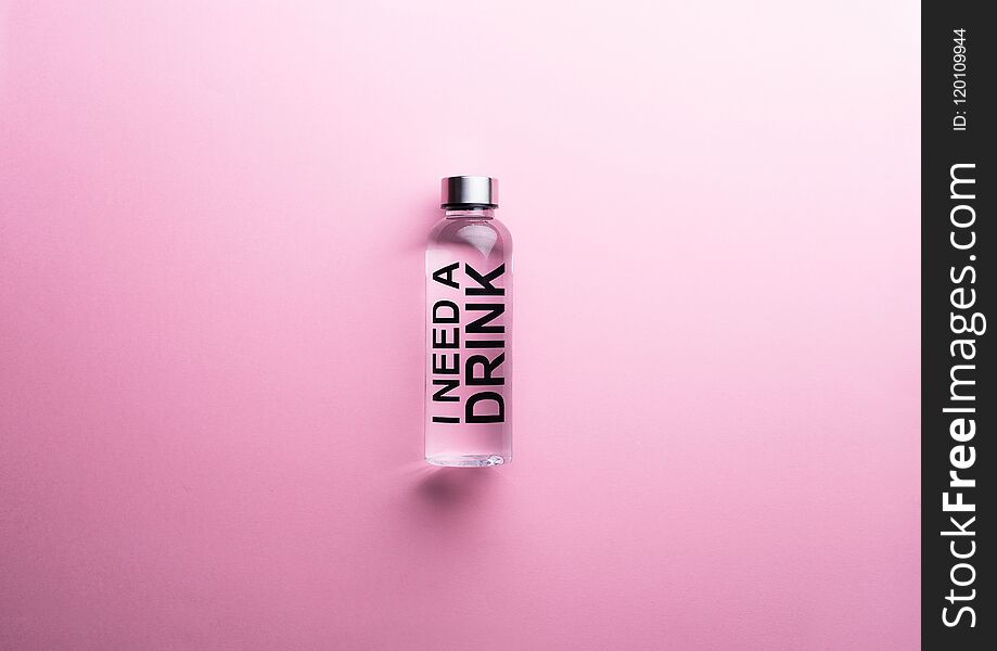 `I need a drink` water bottle over pink background