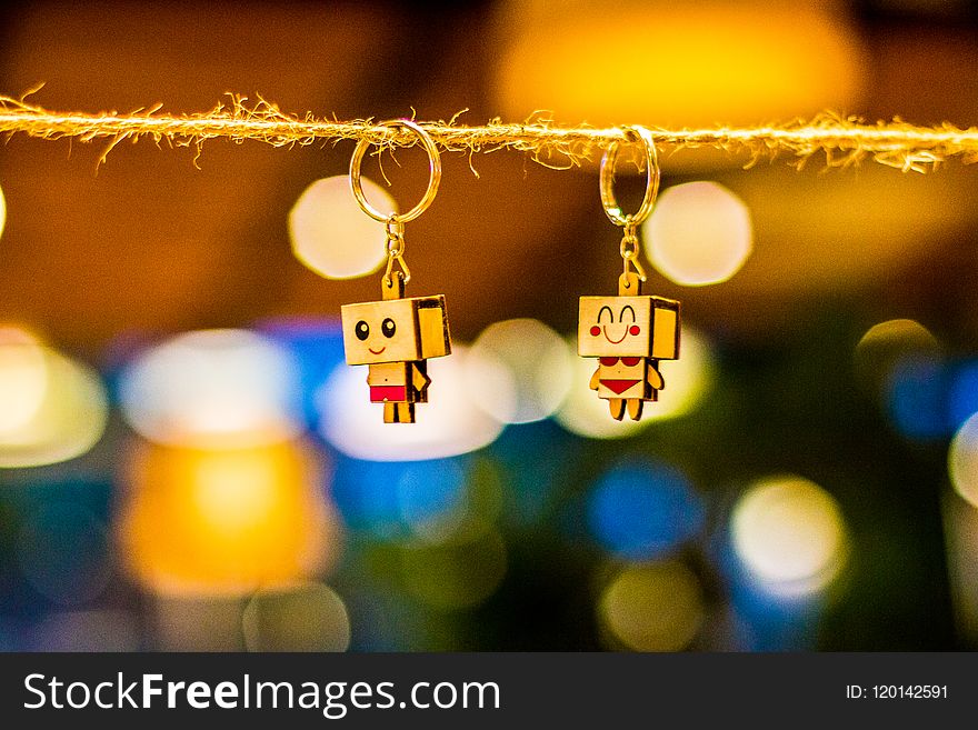 Two Brown Wooden Character Keychains Hanged on Brown Rope