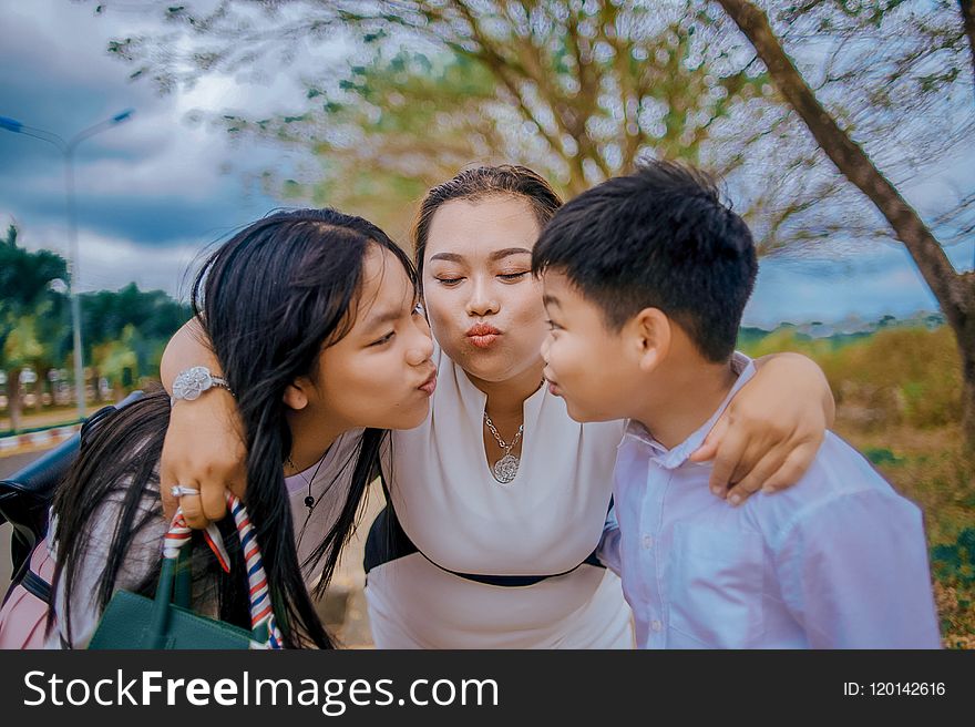 Three Person Kissing Near Tree