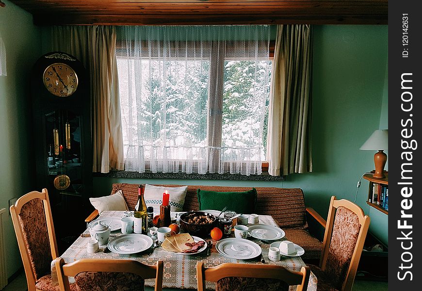 Arranged Table With Chairs and Plates Near Window