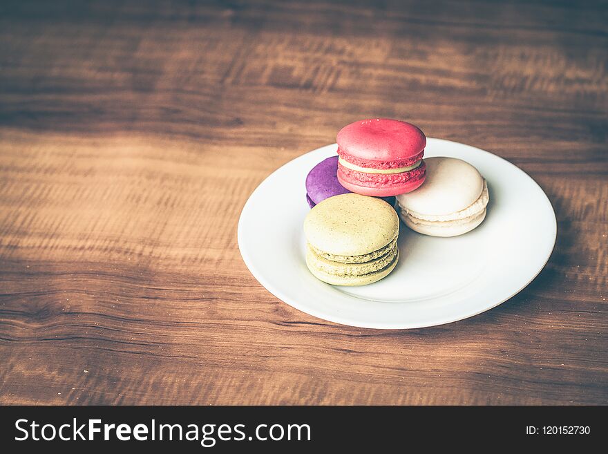 Colorful French Macarons on wooden background.