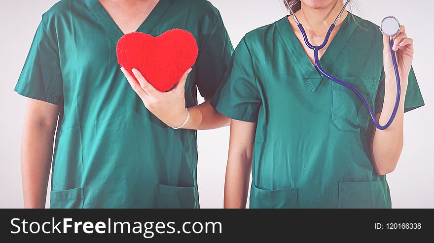 doctor with stethoscope examining red heart.