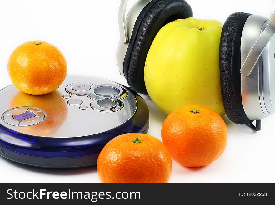 Juicy ripe tangerines and huge yellow apple listen to music through compact player. Juicy ripe tangerines and huge yellow apple listen to music through compact player.