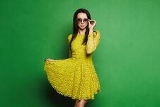 Free Beautiful, And Fashionable Brunette Model Girl In Short Yellow Dress And Sunglasses Pulls Up The Hem Of Her Dress And Posing Stock Photo - 120300690