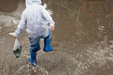 Little Boy Running Around The Puddles. Royalty Free Stock Photography