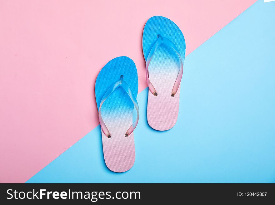 Stylish beach flip-flops on color background, top view
