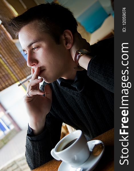 Young Man Smoking In A Restaurant