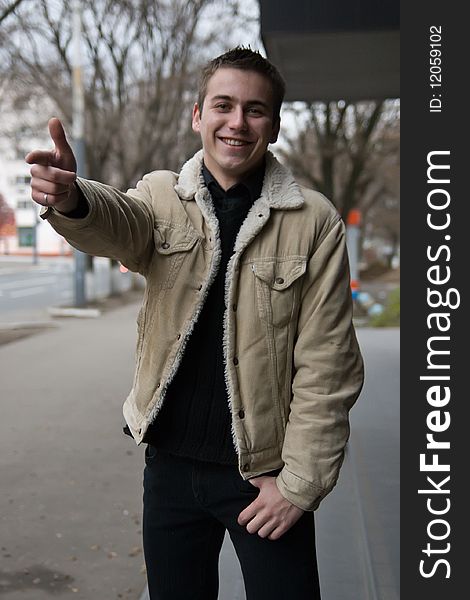 Young man pointing in positive mood pointing with his finger. Young man pointing in positive mood pointing with his finger