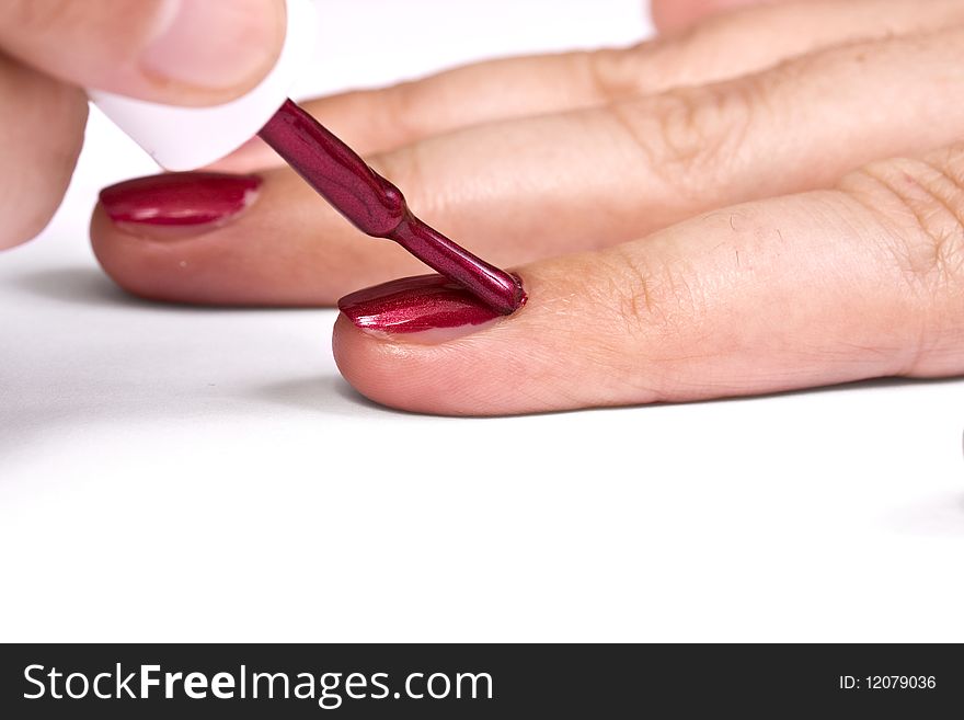 Woman applying red nail polish isolated on white background. Woman applying red nail polish isolated on white background