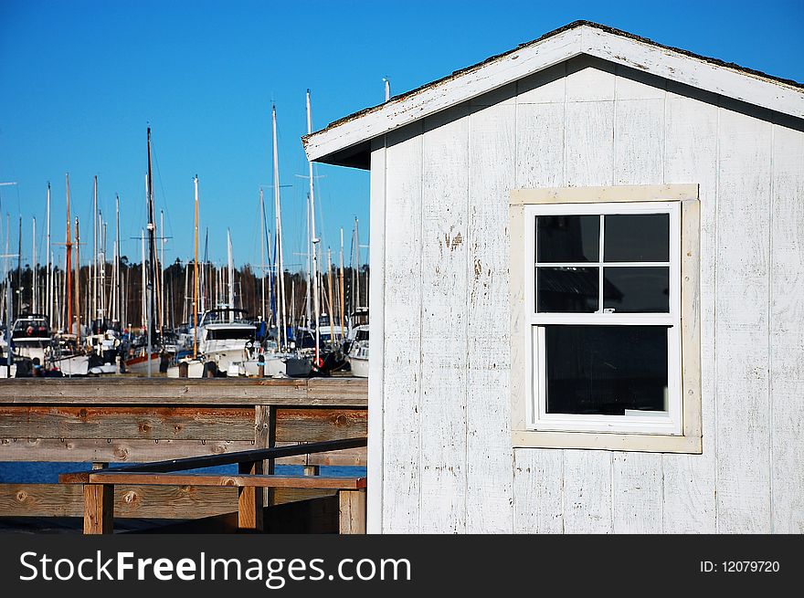 Old boat house on marina with boats in the background