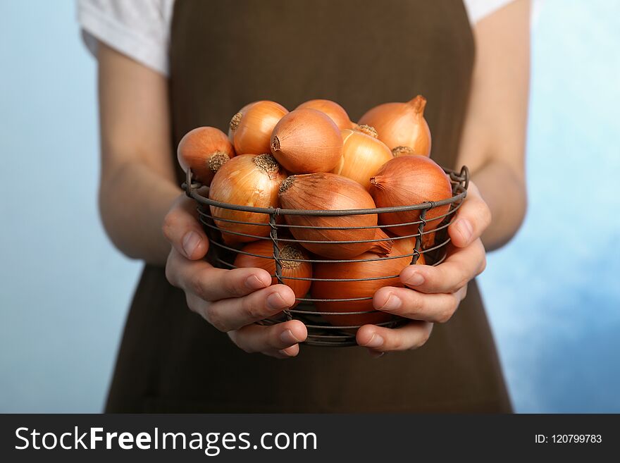 Woman holding basket with ripe onions