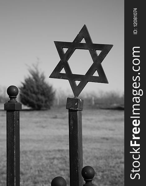 Star of David on wrought iron fence in a cemetery, a symbol for the Jewish people interred there. Monochromatic image. Star of David on wrought iron fence in a cemetery, a symbol for the Jewish people interred there. Monochromatic image