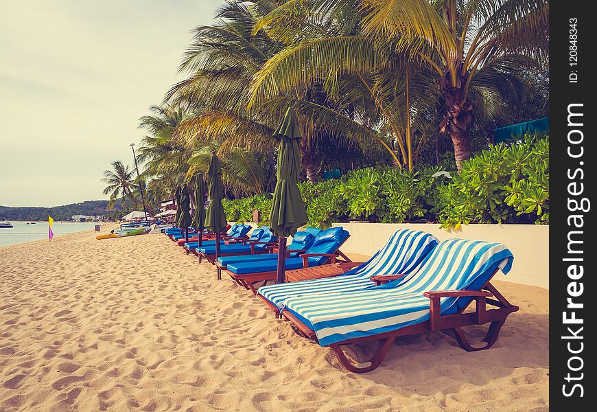 Umbrella and chair on the tropical beach sea and ocean at sunrise time for travel and vacation