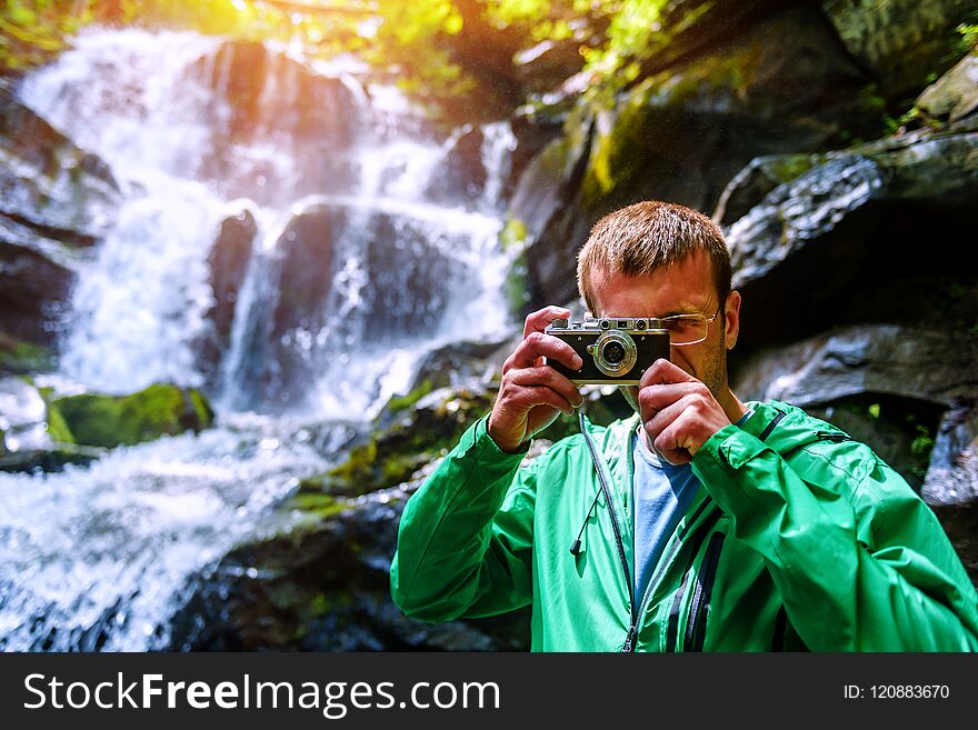 Man With Retro Camera And Waterfall