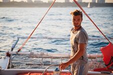 Young Handsome Man, Captain Driving Yacht In Sea At Sunny Day Royalty Free Stock Photo