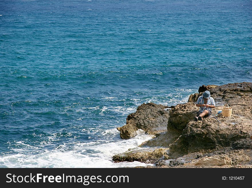 Fishman on the rocks, crete, Greece